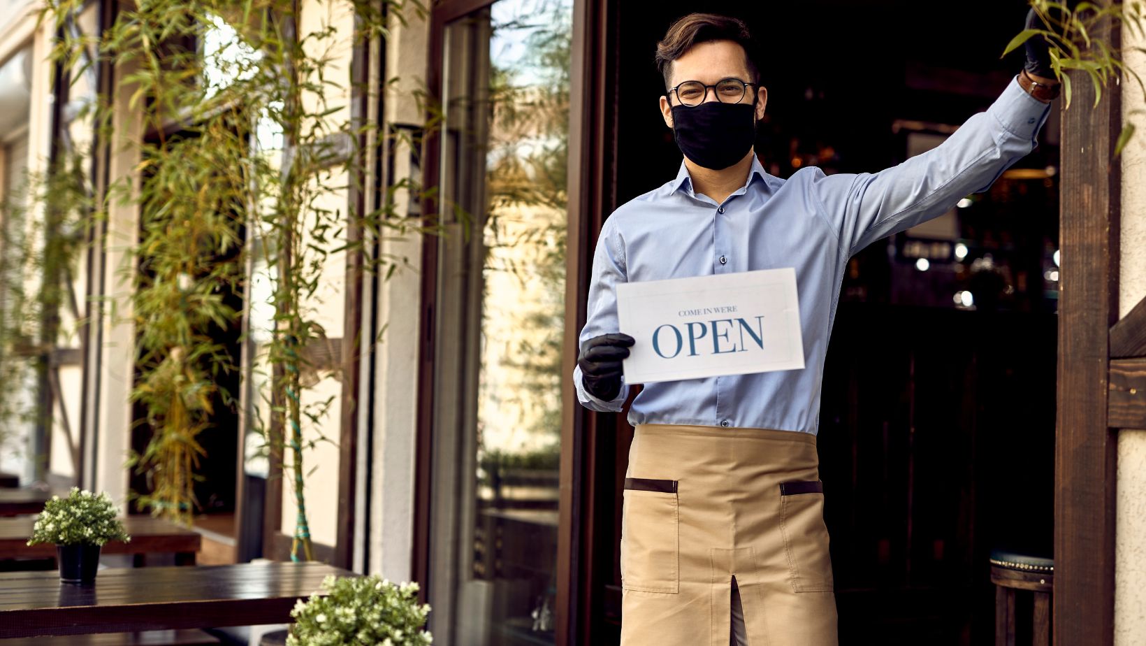 a sale person holding a cardboard and wait for customers on small business Saturday