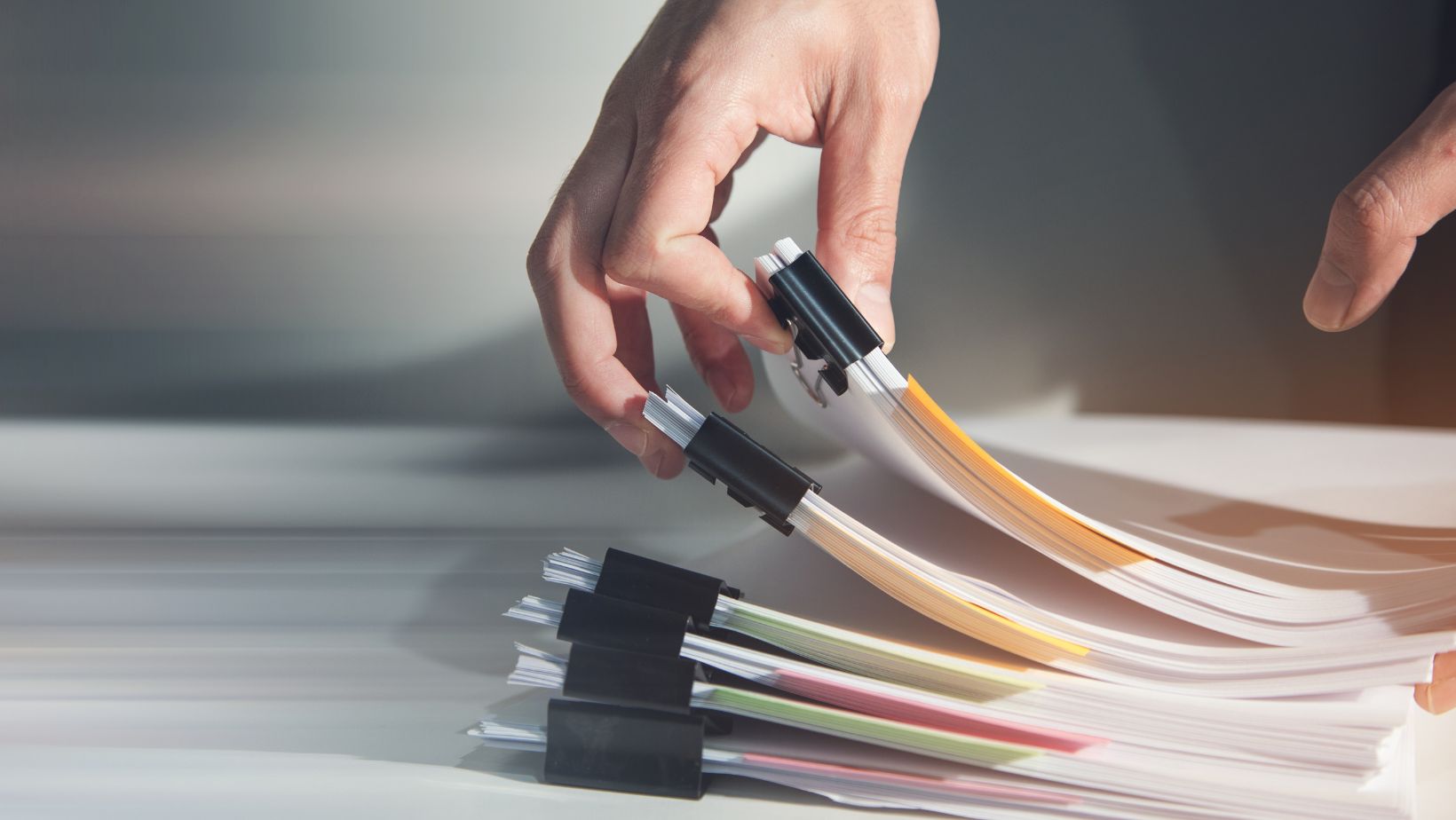 a pile of documents with binder clips